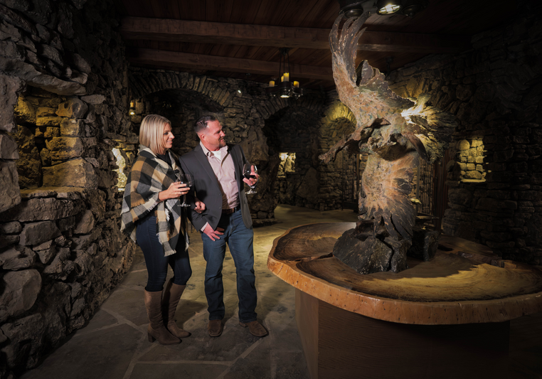 Couple admiring statue and drinking wine